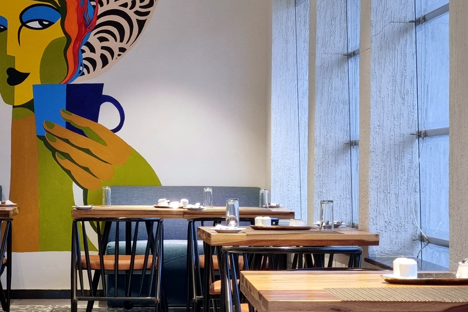 Mural and dining detail at a rooftop café by Karyae